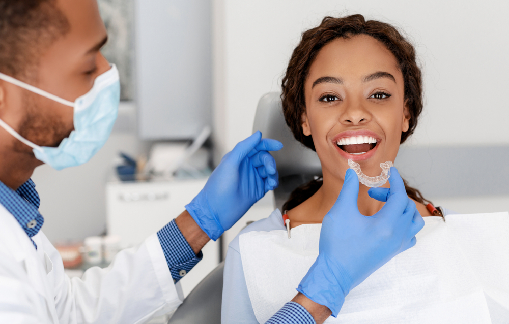 An orthodontist fits a patient with invisible braces. 