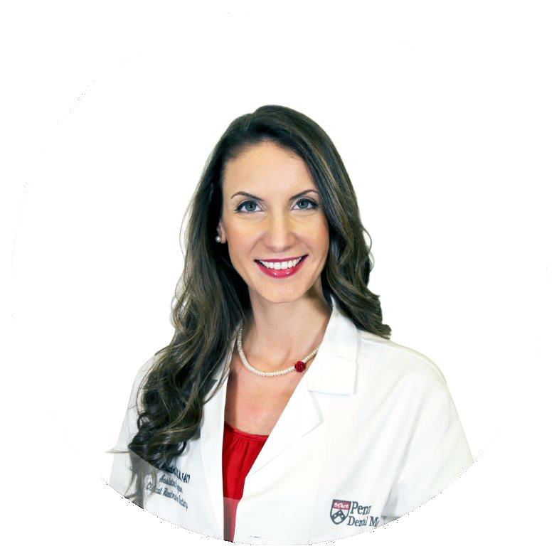 Photograph of Dr. Eva Anadioti, Philadelphia prosthodontist, smiling and wearing white Penn Dental Medicine dentist’s jacket.