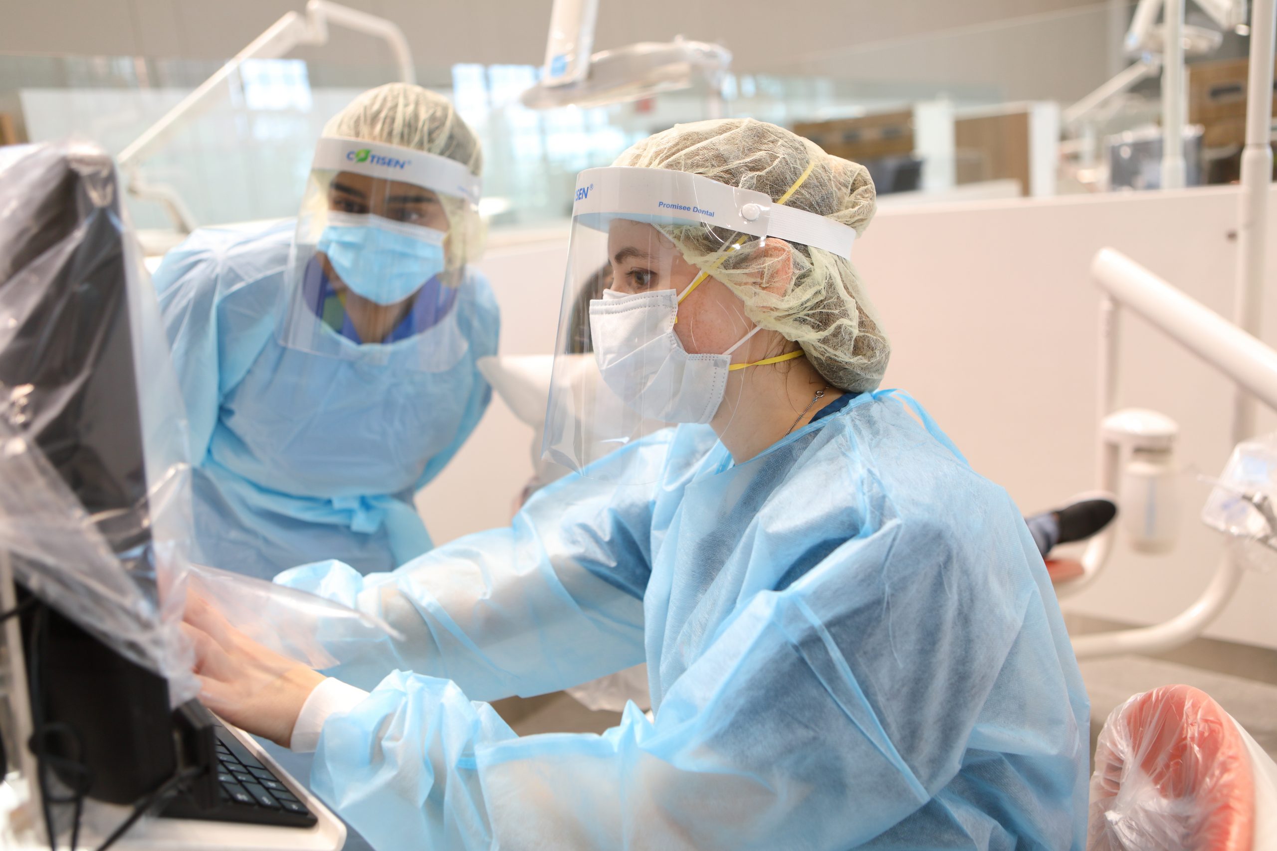 Philadelphia family dentists in an exam room are looking at information on a screen before they see a patient.