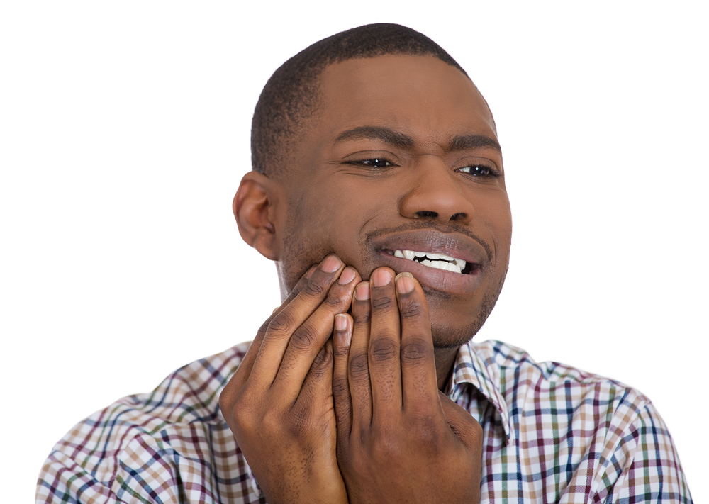  A young man holds his hands to his jaw as he thinks about what to use for receding gums.