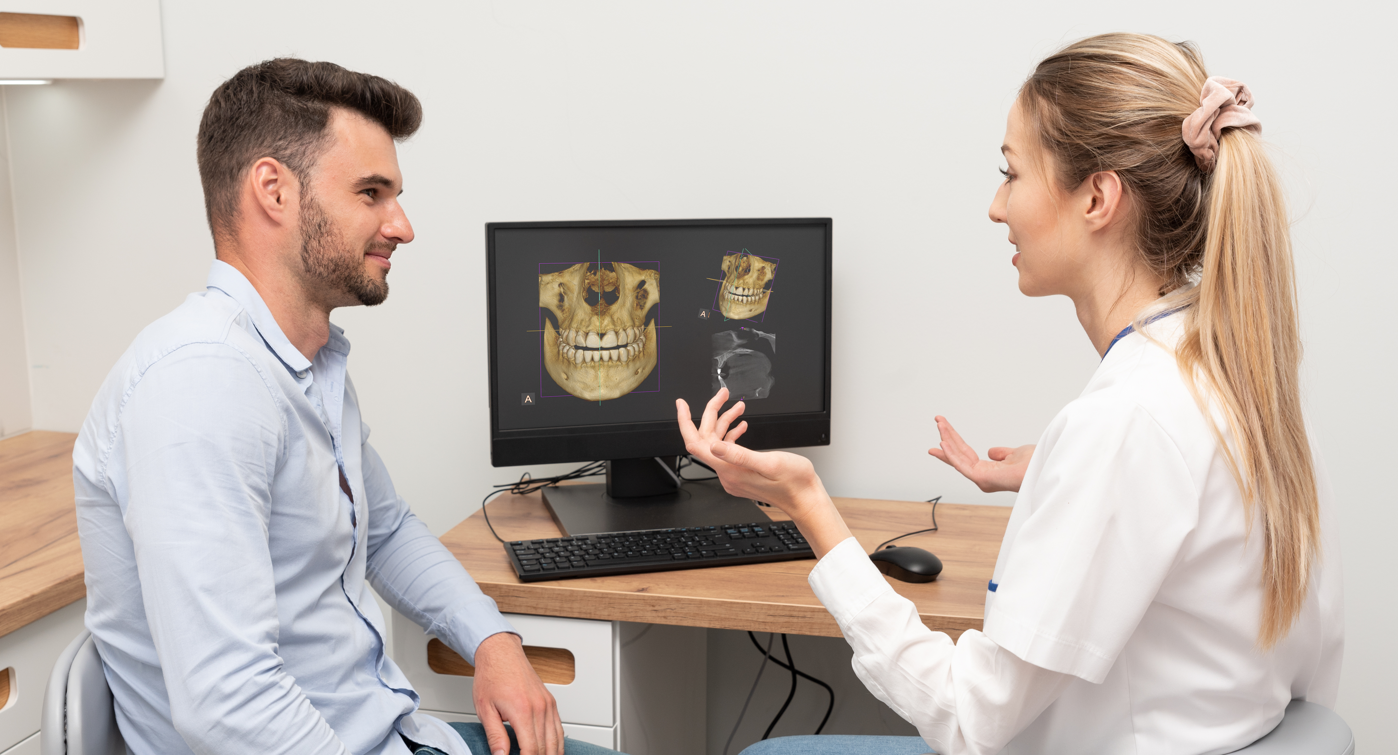 Computer diagnostics dental tomography. Dentist shows the patient an x-ray image on display. Dental care concept.