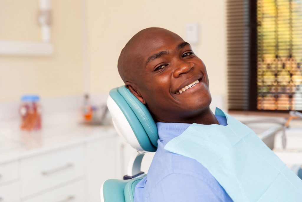 A smiling young male dental patient wonders, “Is chewing gum bad for your teeth?”