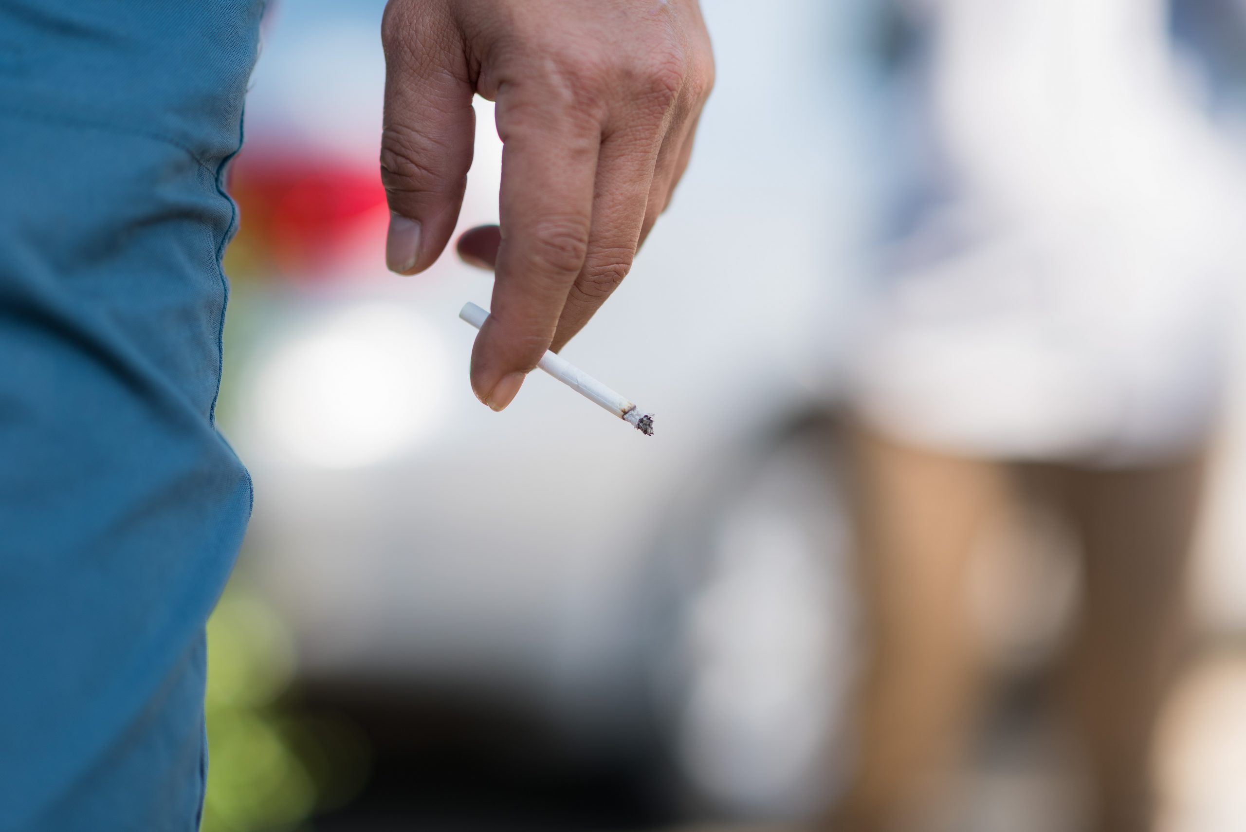 A man holds a cigarette. The use of tobacco products is one of the strongest oral cancer risk factors.