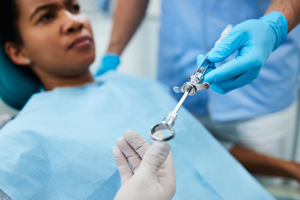  A young woman at the PDFP office waits in the exam chair while novocaine is handed over for her oral surgery procedure.