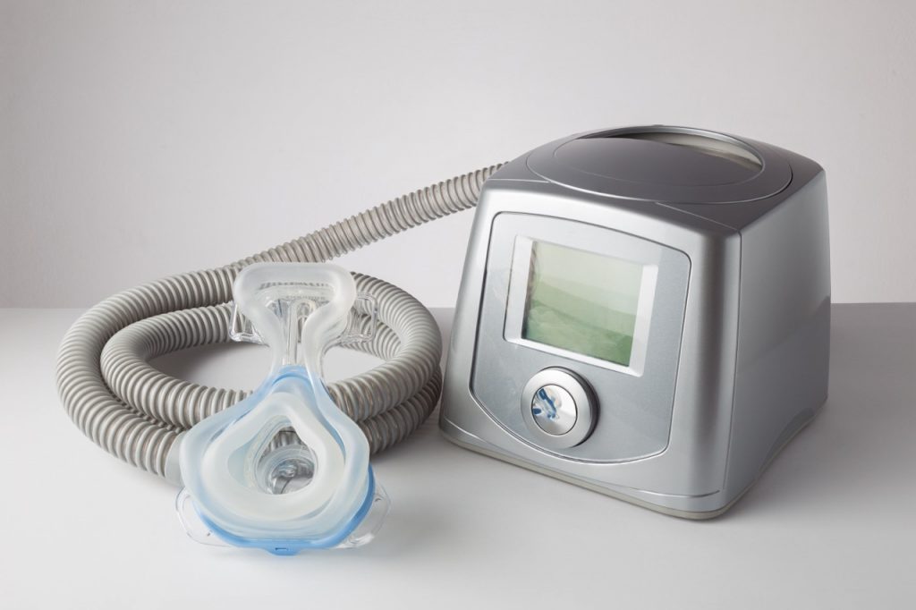 A CPAP with a mask and hose used for sleep apnea and dental health. 