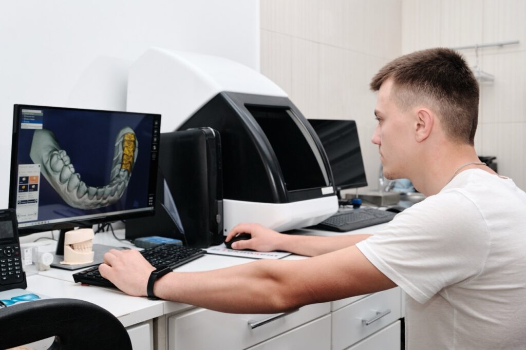 Prosthodontist In dental laboratory uses computer to design a prosthetic jaw for a dental prosthetics patient.