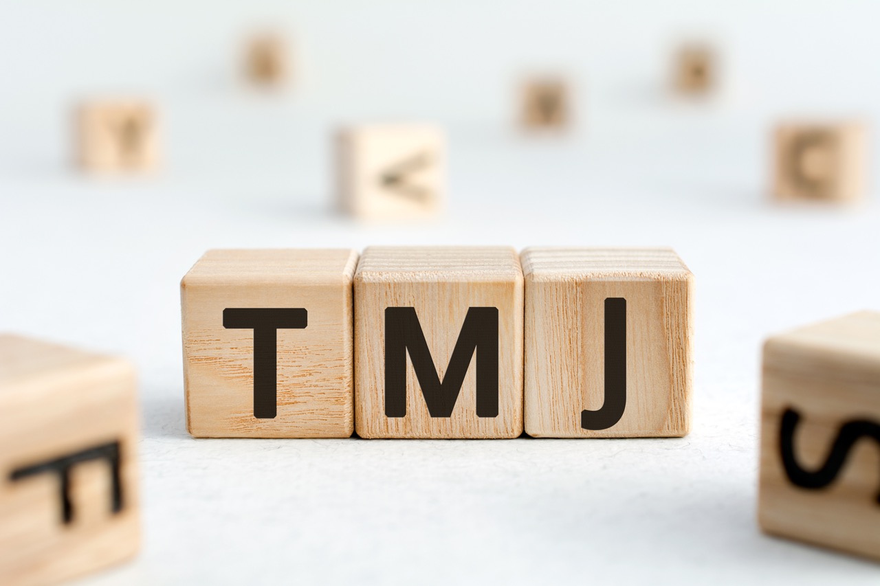 Wooden blocks spell out TMJ. 